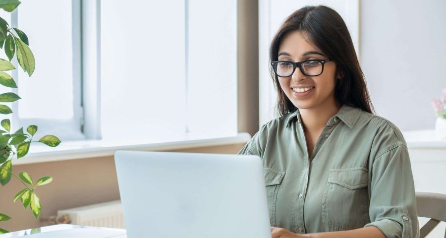 smiling woman typing on laptop