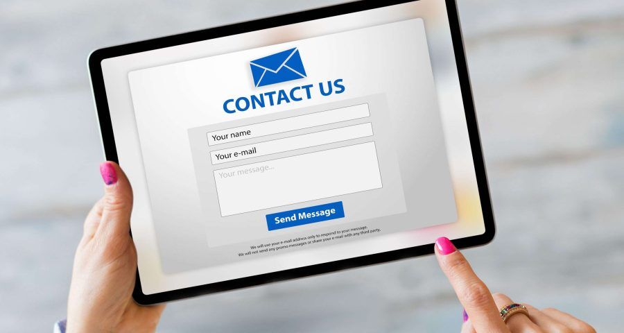 person clicking contact form on tablet
