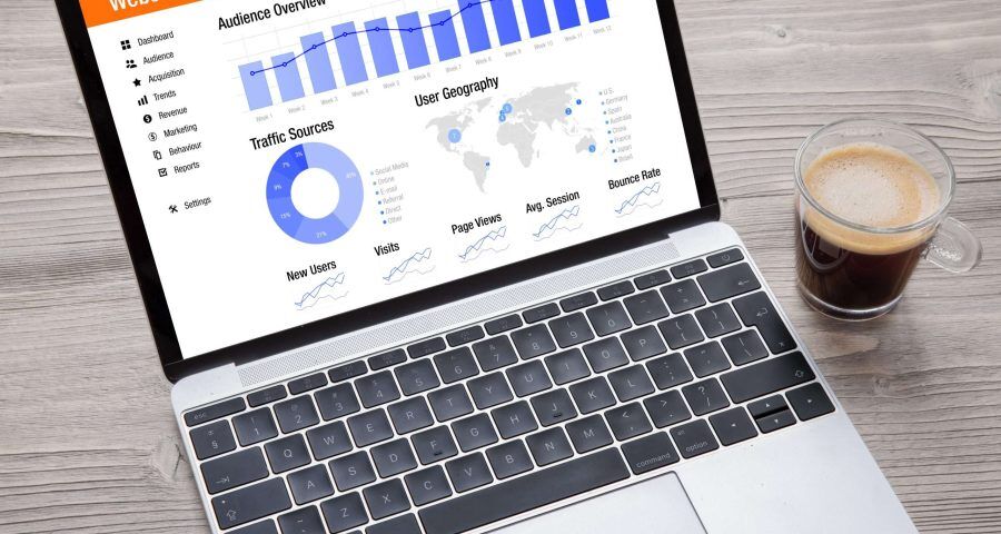 website traffic analytics on a laptop with a cup of coffee next to it