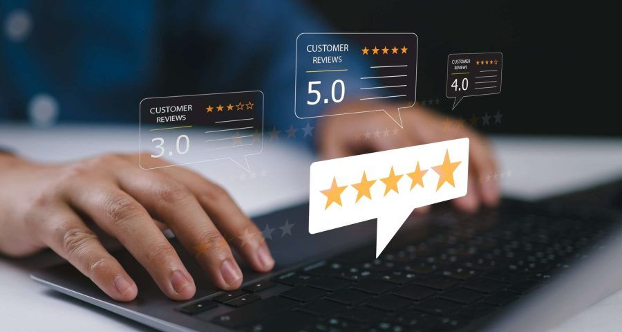 Hands typing on a laptop with floating five-star customer review graphics