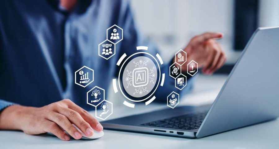 Graphic of AI wording above a man using a laptop