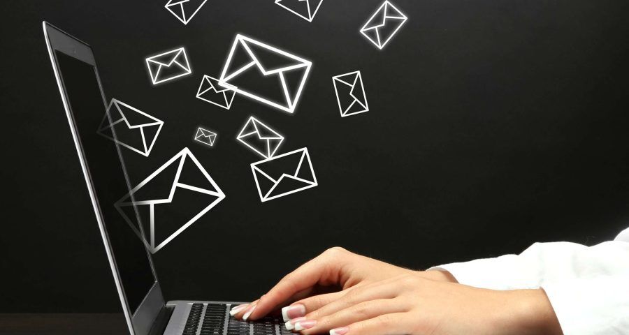 Someone sending out emails on a laptop