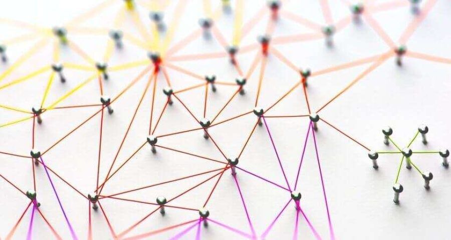 A photograph of rainbow network of pins and threads.